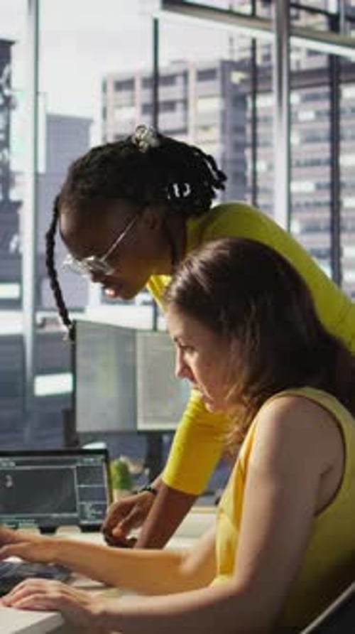 Two Women Coding Together in Office