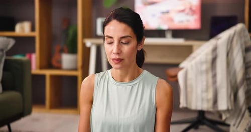 Woman Meditating in Living Room with Eyes Closed