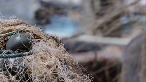 Fischer repariert Fischnetze auf einem Fischerboot in Dock 16