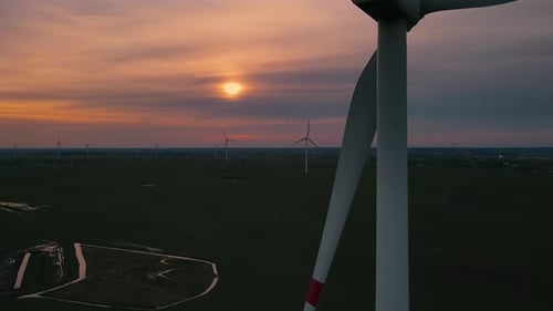 Wind Power Plant Towers in Field Energy Windmills at Sunset with Beautiful Golden Horizon Wind