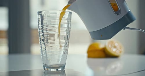 Pouring Fresh Orange Juice into a Glass