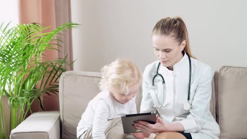 Woman Doctor Showing Tablet to Child Patient