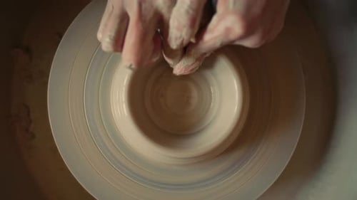 Hands of Craftsperson Forming Clay Bowl on Pottery Wheel