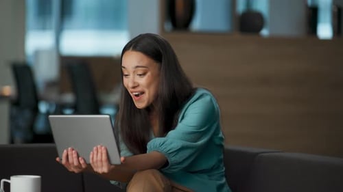Overjoyed businesswoman celebrates success with winning gesture at luxury office lobby