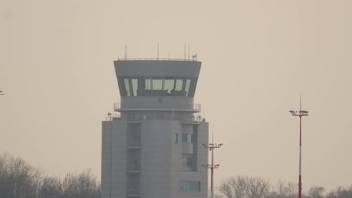 Ein Blick auf einen Flughafenkontrollturm bei Sonnenuntergang vor ruhiger Kulisse
