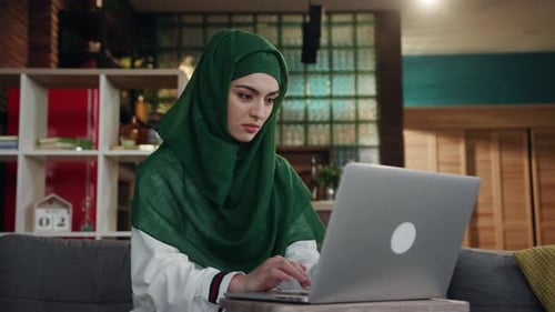 Focused Woman Works on Laptop at Home