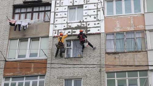 Workers Installing Insulation on Apartment Building Facade