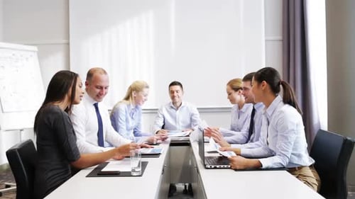 Smiling Team Discussing Documents and Cheering Success