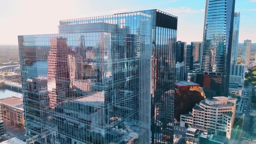 Rising along amazing high-rise glass buildings reflecting the cityscape.