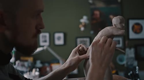 Sculptor Creating Female Clay Figure With Tool