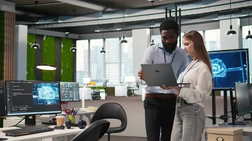 Junior Dev and Colleague in Office Reviewing AI System Metrics