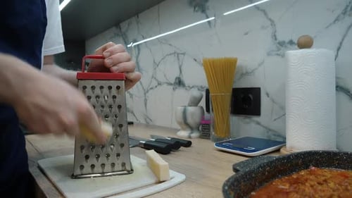 Man Grating Cheese in a Modern Kitchen