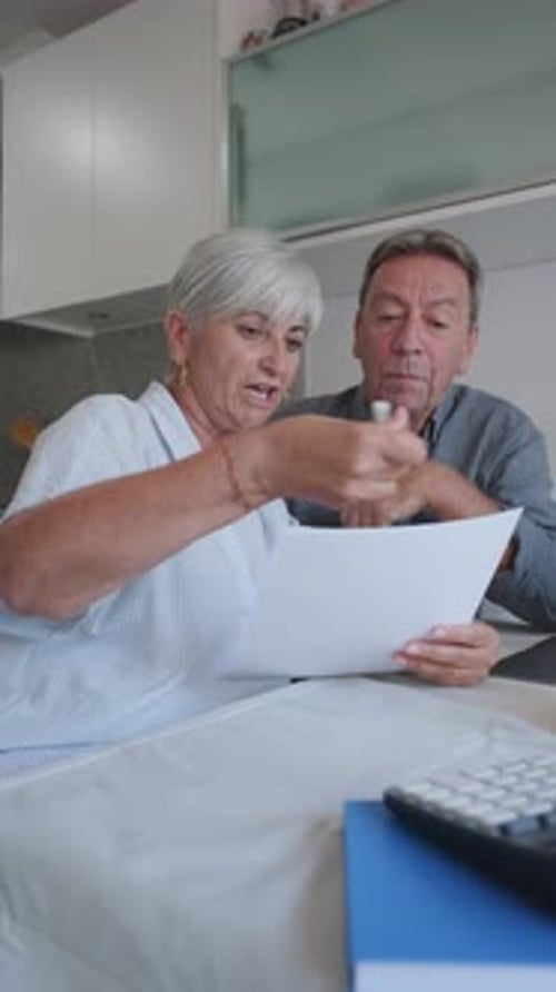 Older Couple Reviews Documents at Home
