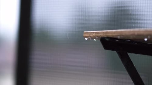 Raindrops Gracefully Falling Down From the Wooden Edge Create a Serene and Soothing Atmosphere
