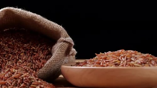 Uncooked Brown Rice in Burlap Sack and Wooden Bowl