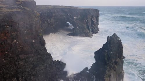 Rough wild sea clashing on the high cliffs on Iceland on a stormy day. Wide view