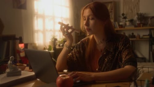 Woman using laptop and talking on cell phone