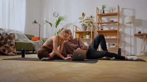 Woman and Man Using Laptop on Yoga Mat