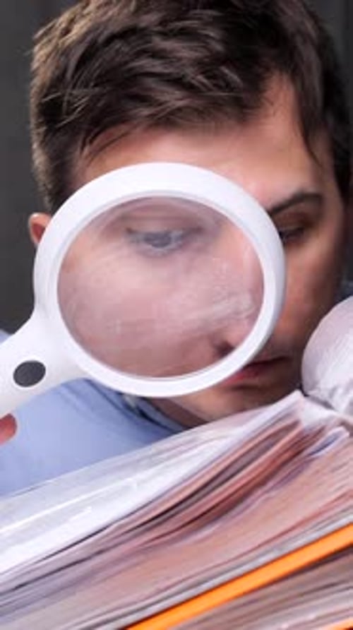 Vertical Video Accountant Examining Documents with Magnifying Glass