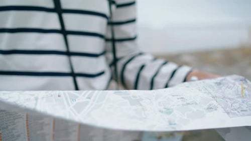 Woman Reading a Map while Traveling in City
