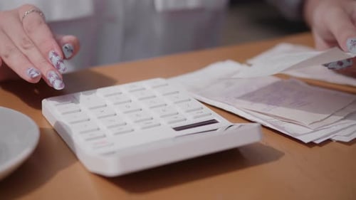 Calculator Use and Expense Tracking at a Local Business Office Meeting Over Morning Coffee