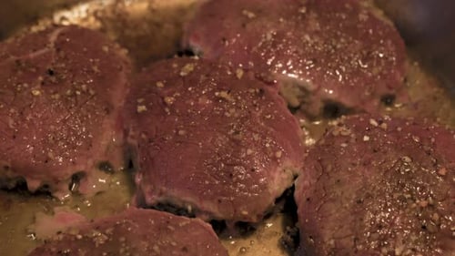 Raw Steak Sizzling in Skillet Close Up