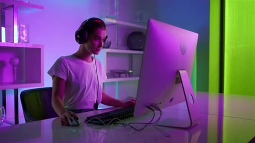 Young Woman Gaming Online in Purple Lit Room