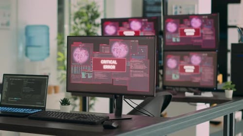 Empty It Office Desk with Multiple Computers Showing Security Breach Warning