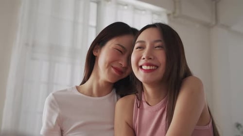 Two asian Young women are laughing together in a room