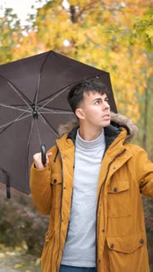 Young Adult Opens Umbrella in City Park