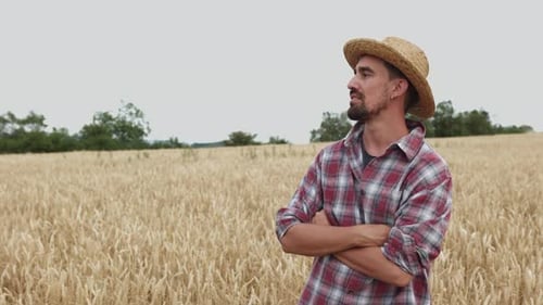 Young Adult Male Farmer Smiling at Camera Standing at Wheat Field