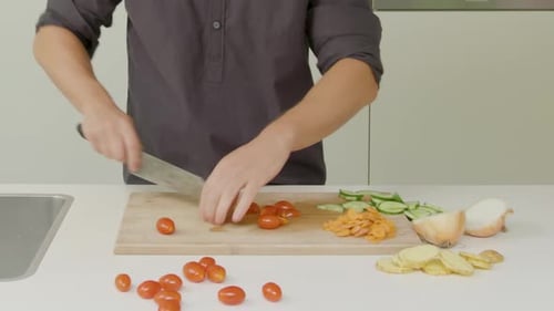 Adult Chopping Vegetables with Knife on Cutting Board