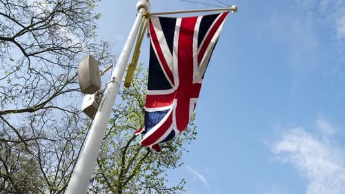 Looking Up At Union Jack Flag Waving In Wind. Slow Motion