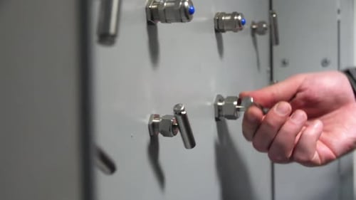 Employee Turns Lever on Control Panel in Plant Workshop