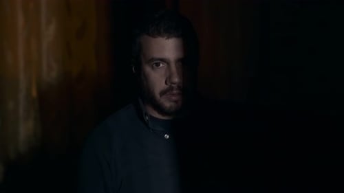 Adult Man Holds Gun in Dark Room