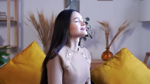 Woman Relaxing with Eyes Closed at Home