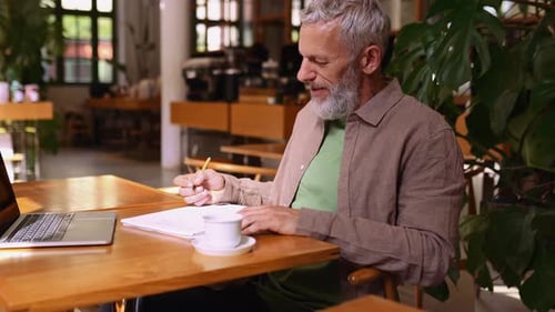 Mature Man Working at Cafe with Laptop