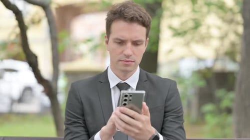Man in Suit Using Phone Outdoors