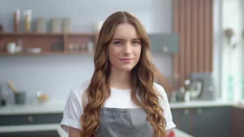 Smiling Woman in Apron in Bright Kitchen