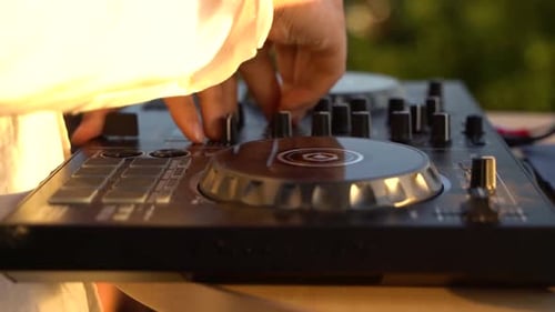 Close up of person outdoor DJing in the sunset.