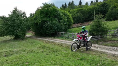 Aerial Shot of a Motocross Rider on a Journey on a Dirt and Dusty Country Road Driving Fast and