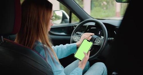 Close up. Woman hands holding mobile telephone with a vertical green screen in car chroma key smartp