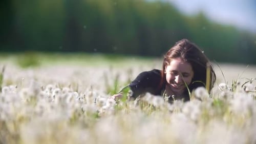Young Cheerful Woman Having Fun Into a Field of Dandelions