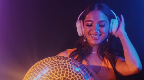 Woman With Headphones Holding a Disco Ball