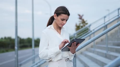 Woman Using Tablet Outdoors in Urban Setting