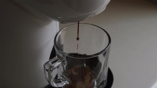 Coffee Maker Filling Clear Glass Mug with Espresso