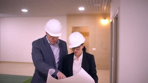 Businessman Helmet Man Woman Engineers with Drawing Blueprint at Room Apartment Decoration Office