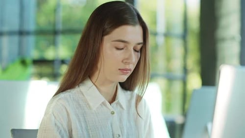 Focused Attractive Businesswoman Working Using Computer Typing on a Keyword in Sunlight Office