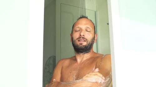 Man washing body with soap in shower