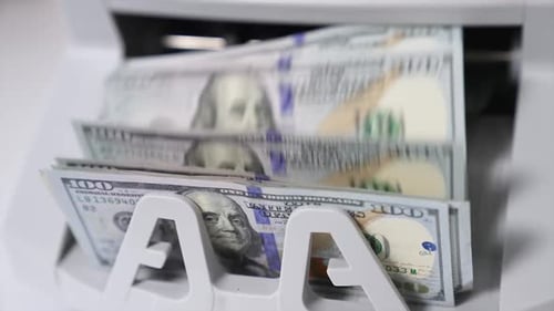 Money Counting Machine Counts Stack of Dollar Bills